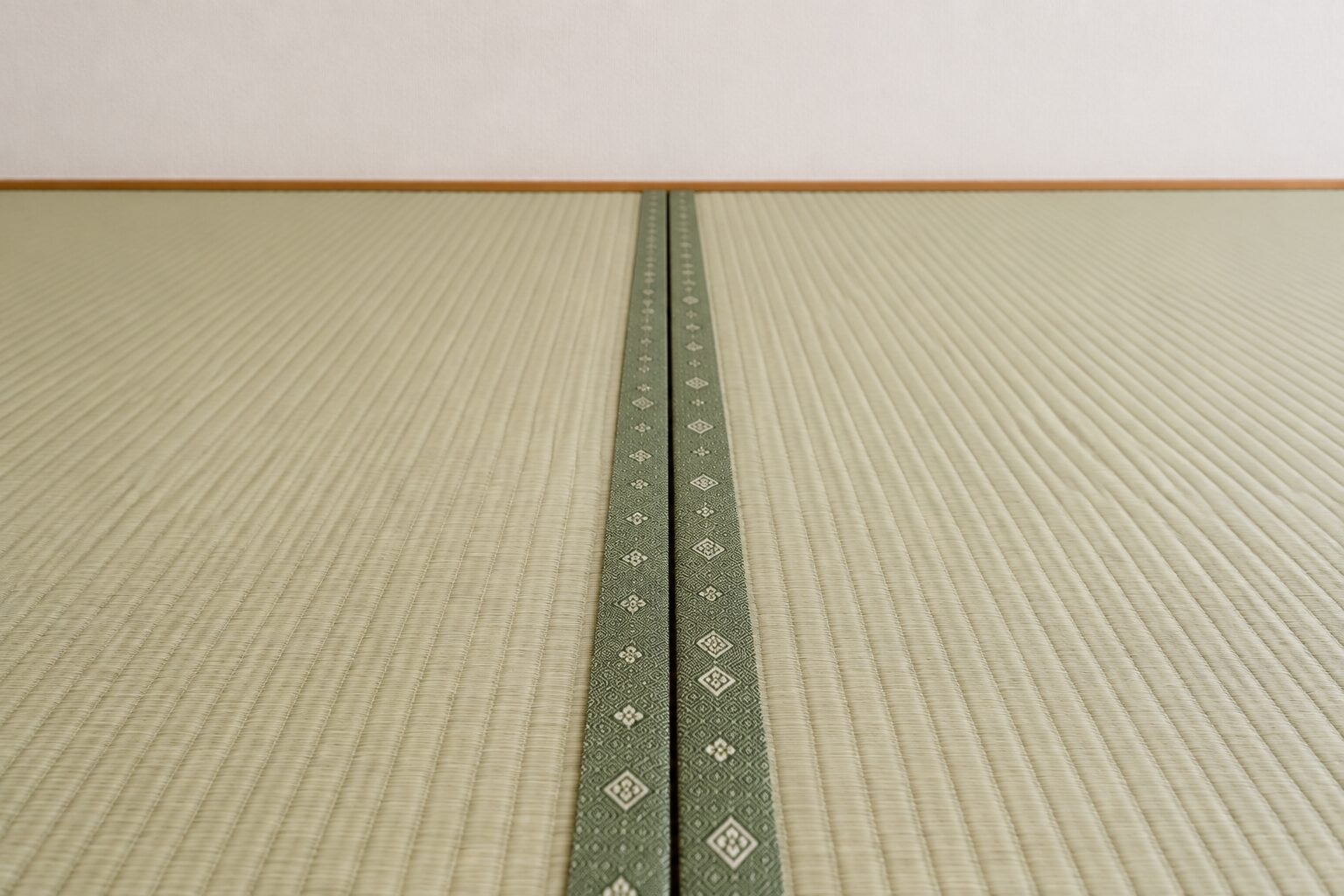 長辺側の畳縁どうしの間にできた隙間を確認する様子